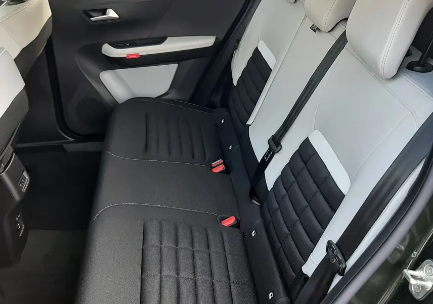 Vue intérieure côté arrière droit montrant les sièges arrière bicolores noir et blanc du Citroën C3 Aircross hybride 2026.