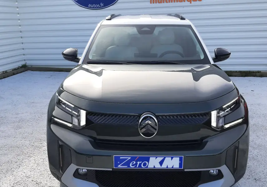 Vue avant centrée du Citroën C3 Aircross hybride 2026 en vert Montana avec toit blanc opale et calandre noire distinctive.