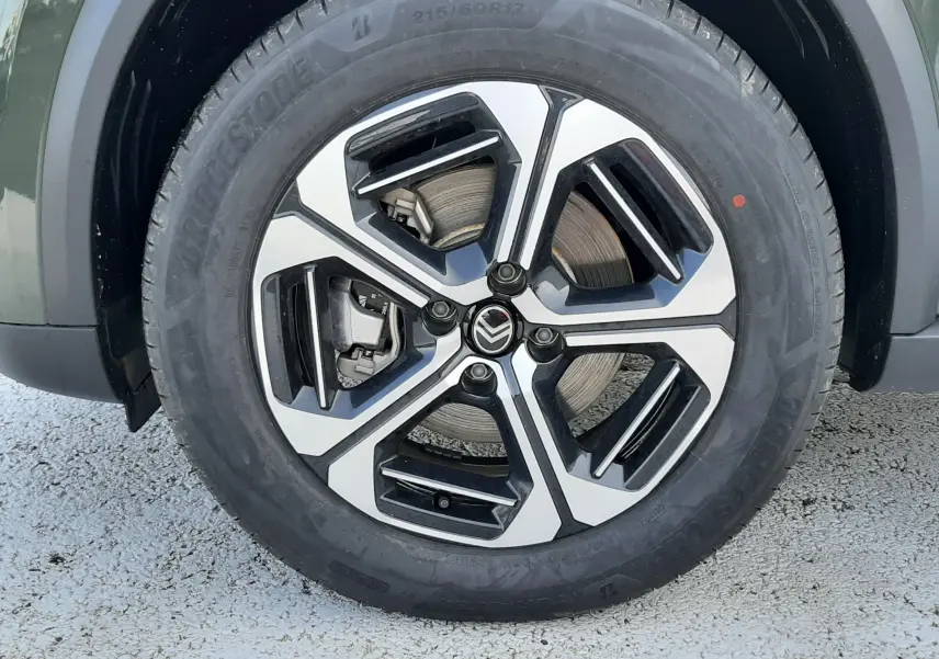 Gros plan sur la roue avant droite d'une Citroën C3 Aircross hybride 2026, jante alliage bicolore noir et argent.