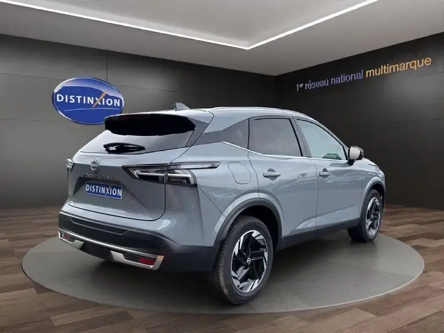 Vue 3/4 arrière droite du Nissan Qashqai 2025 en gris céramique, avec hayon motorisé et jantes noires distinctives.