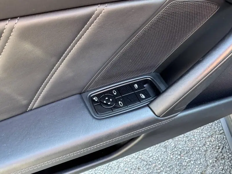 Gros plan sur la commande des vitres et rétroviseurs sur la porte intérieure noire en cuir de la Porsche 911 Turbo S 2020.