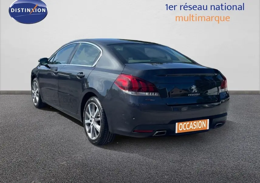 Peugeot 508 noire en 3/4 arrière droit, version GT Line avec feux arrière LED et double sortie d’échappement.