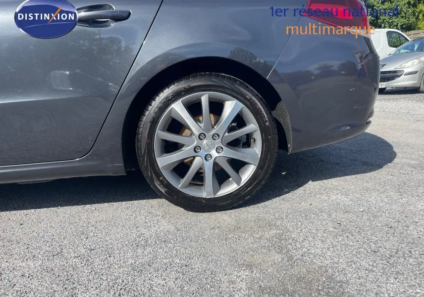 Gros plan sur la roue arrière droite d'une Peugeot 508 noire 2026, version 2.0 BlueHDi GT Line, sur un sol goudronné.