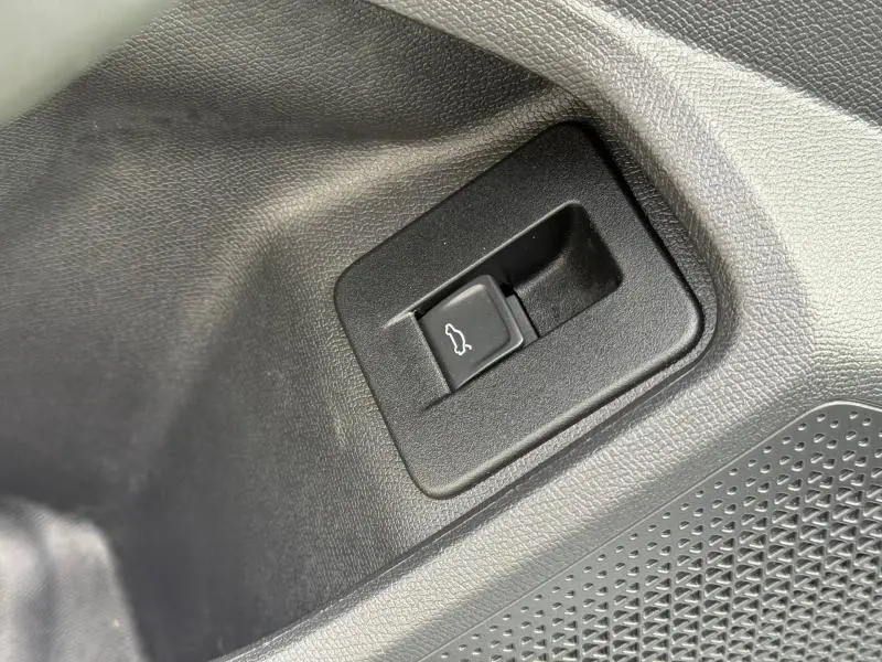 Bouton d'ouverture du coffre en gros plan sur la porte intérieure d'un CUPRA Formentor 2.0 TDI 150ch blanc Nevada métallisé.
