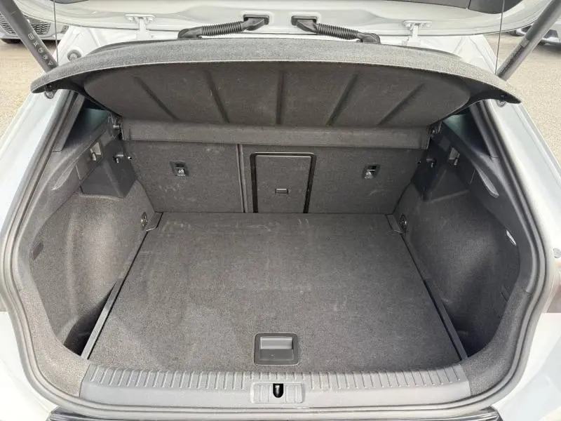 Coffre ouvert vu de l’arrière d’un CUPRA Formentor blanc Nevada métallisé, montrant un espace de chargement vide et propre.