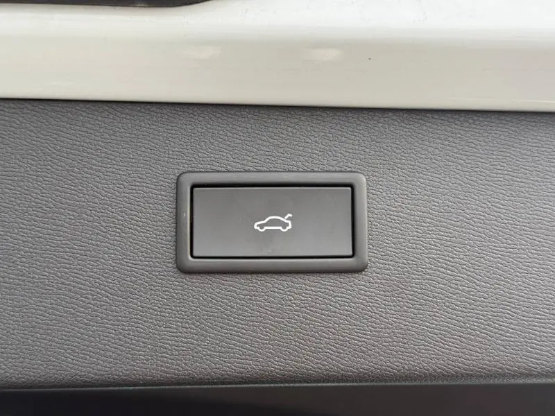 Bouton intérieur noir avec pictogramme blanc d'ouverture de coffre sur tableau de bord du CUPRA Formentor blanc Nevada 2025.