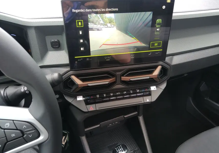 Vue intérieure centrée sur l'écran tactile et la console centrale du Dacia Bigster gris schiste avec boîte manuelle.