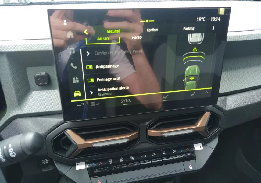 Écran tactile central du tableau de bord du Dacia Bigster 2025 avec commandes de sécurité et aérateurs bronze.