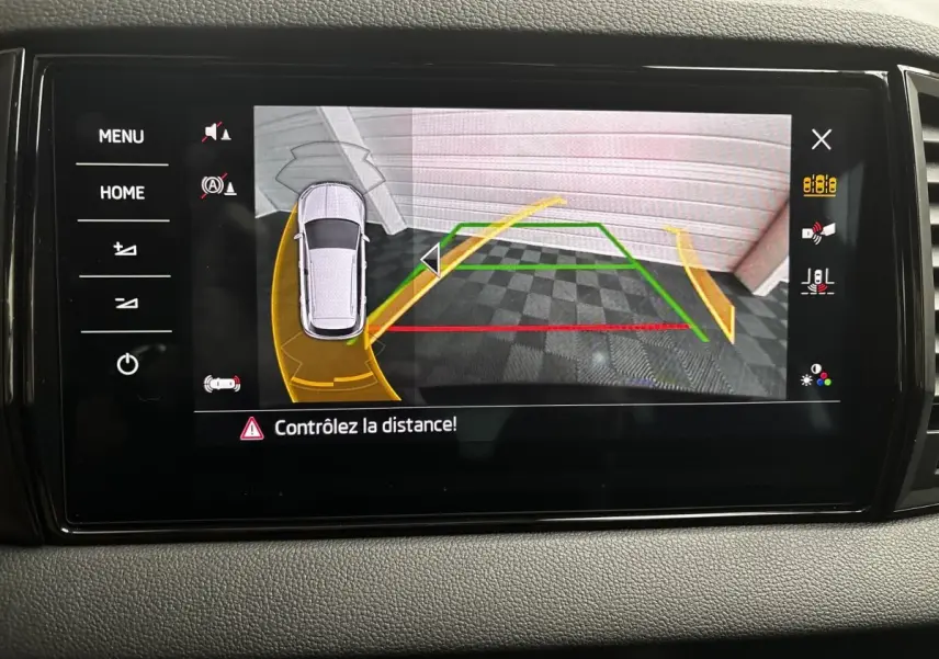Écran tactile central montrant la caméra de recul avec guidage dynamique sur Skoda Karoq noir, vue intérieure du tableau de bord.