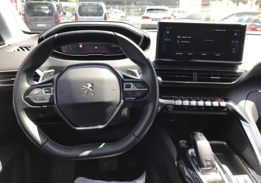 Vue intérieure du poste de conduite du Peugeot 3008 2022, volant compact cuir et écran tactile 10 pouces central.