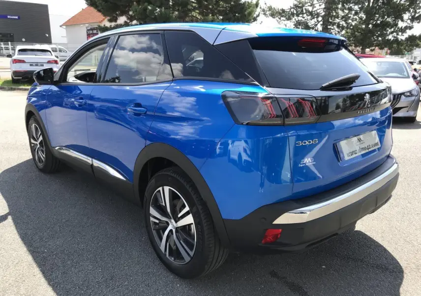 Vue 3/4 arrière droite d’un Peugeot 3008 bleu Iron avec jantes alliage bi-ton et vitres arrière surteintées.