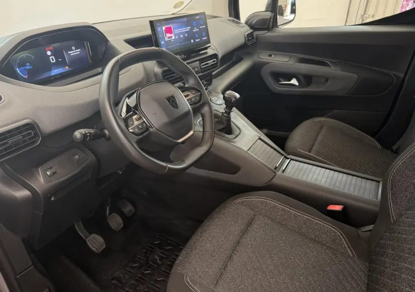 Vue intérieure côté conducteur du Peugeot Rifter 2024, volant cuir multifonctions et écran tactile central visible.