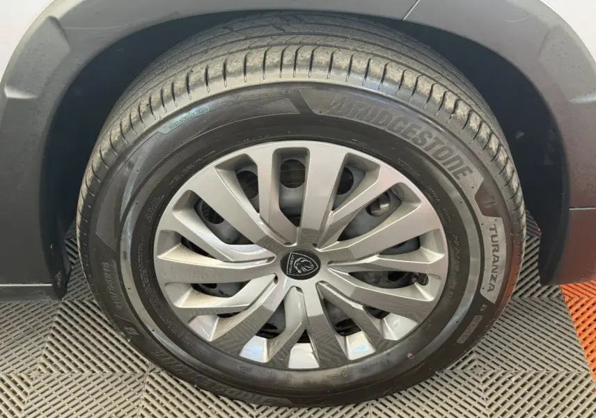 Gros plan sur la roue avant gauche du Peugeot Rifter gris clair, avec jante en alliage et pneu Bridgestone Turanza.
