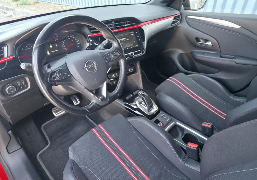 Vue intérieure avant droite de l’Opel Corsa GS Line 2020, sièges sport noirs avec bandes rouges et volant cuir multifonction.