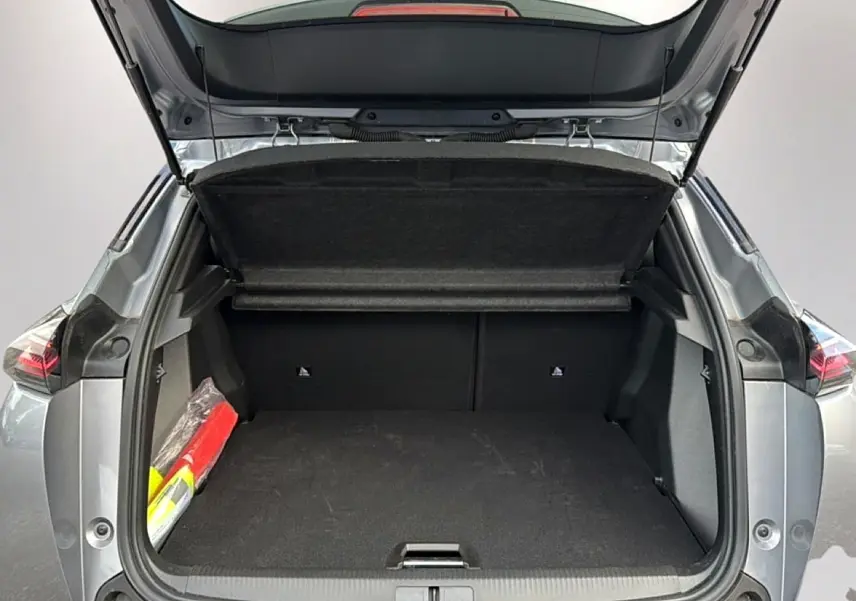 Coffre ouvert vu de l'arrière d'un Peugeot 2008 gris artense avec banquette rabattable et cache-bagages.