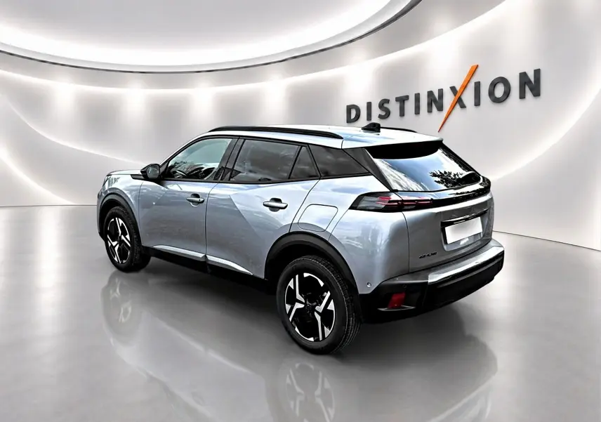Peugeot 2008 gris Artense en 3/4 arrière droit, avec jantes alu noires et toit noir dans un showroom lumineux.