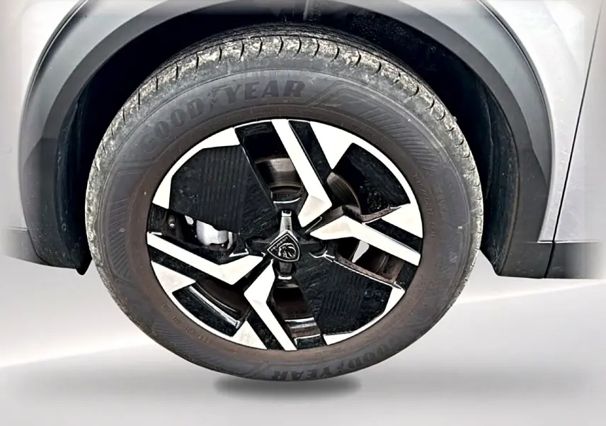 Gros plan sur la roue avant gauche gris artense du Peugeot 2008 1.2 100 allure avec jante alu bicolore distinctive.