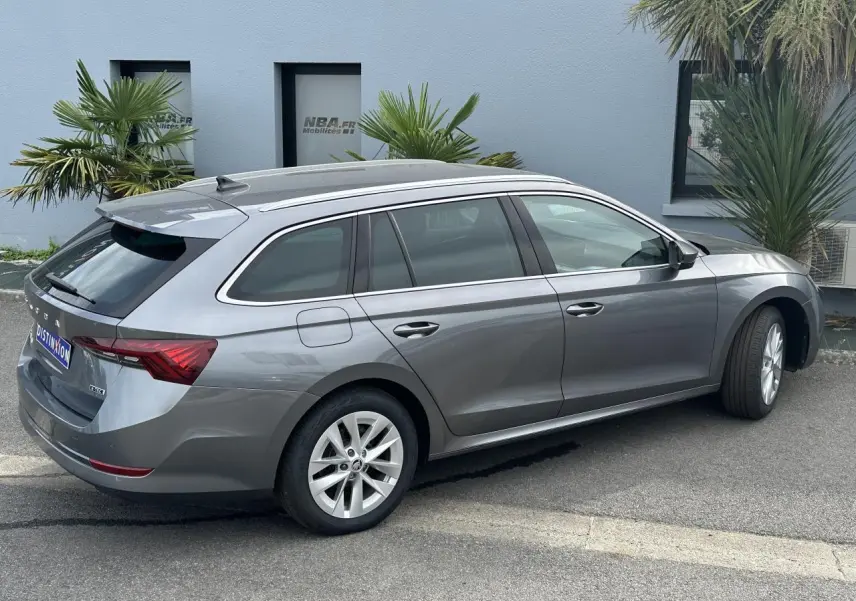 Vue de profil côté droit d'une Skoda Octavia Combi gris graphite avec feux arrière LED et vitres teintées.