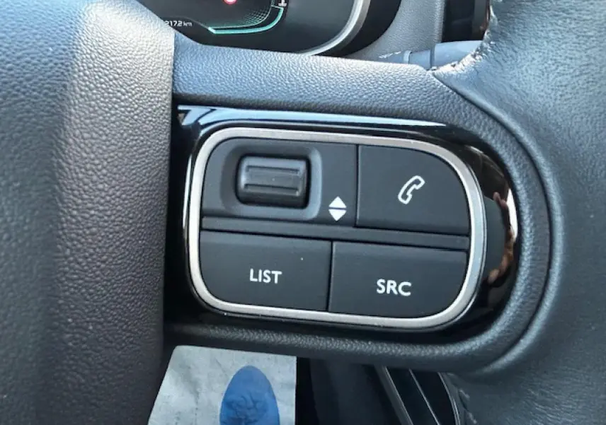 Gros plan sur les commandes au volant gauche du Citroën C5 Aircross 2019 avec boutons noirs et contours chromés.