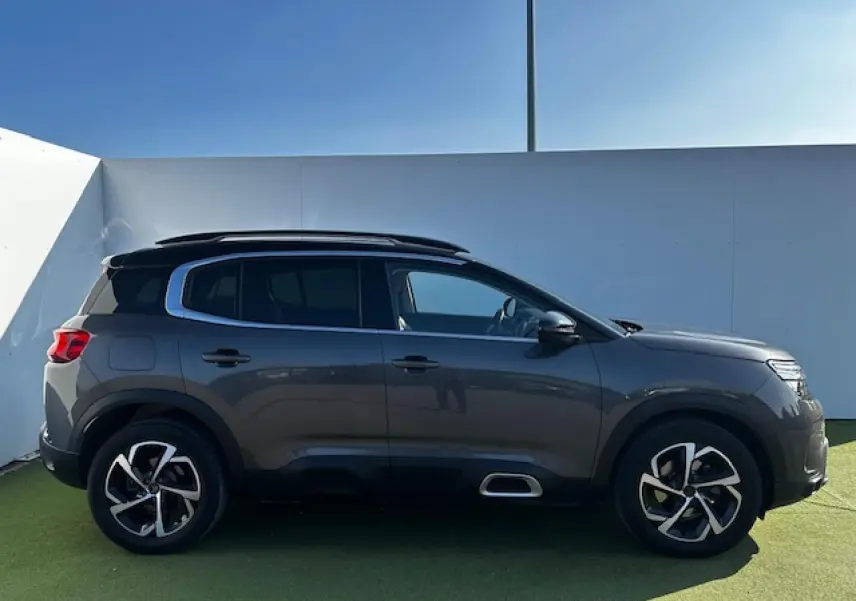 Profil côté gauche du Citroën C5 Aircross gris platinium métallisé avec jantes alliage et vitres surteintées.