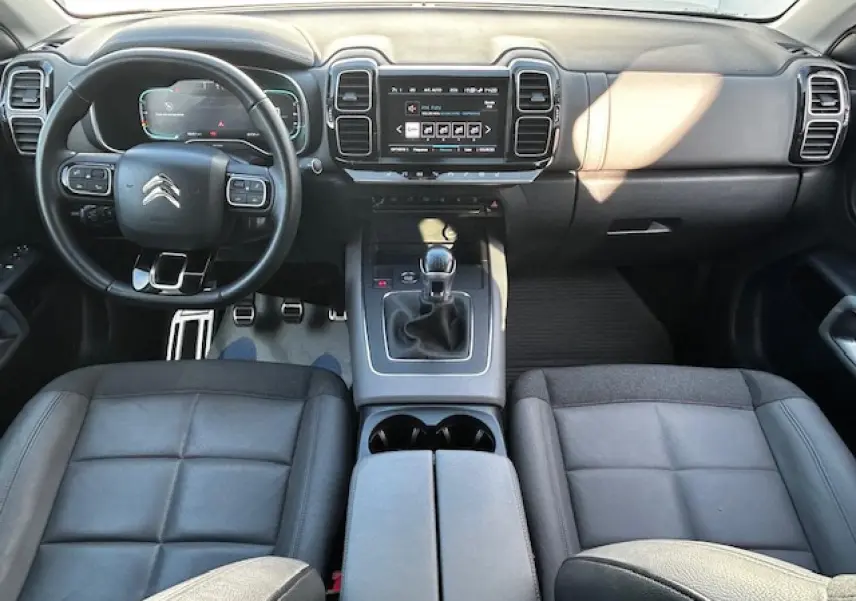 Vue intérieure avant du Citroën C5 Aircross 2019, tableau de bord noir avec volant cuir et levier de vitesse manuel.