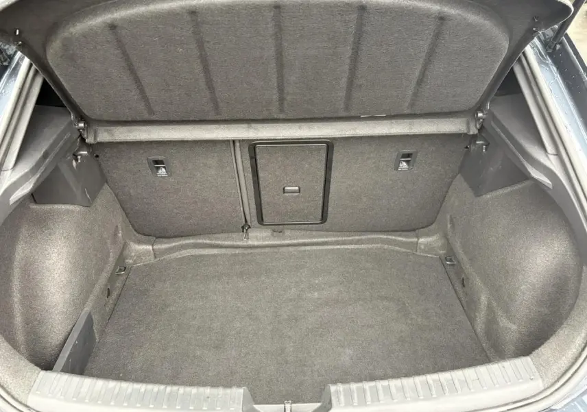 Coffre ouvert du SEAT LEON 1.5 e-TSI 150 DSG7 FR 2024 en Gris Magnétique, montrant un espace de chargement vide et propre.