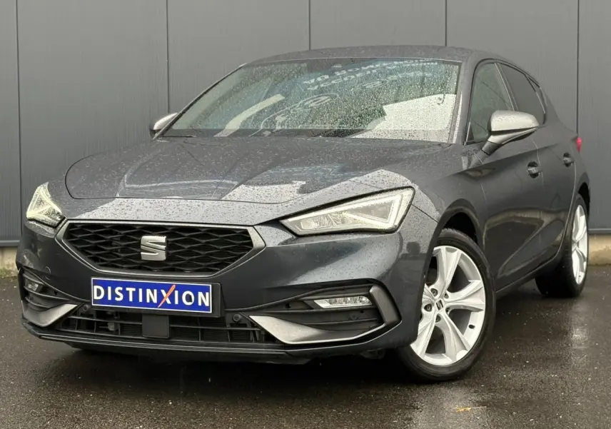 SEAT LEON 1.5 e-TSI 150 DSG7 FR gris magnétique en 3/4 avant droit sous la pluie avec jantes alliage 17 pouces.