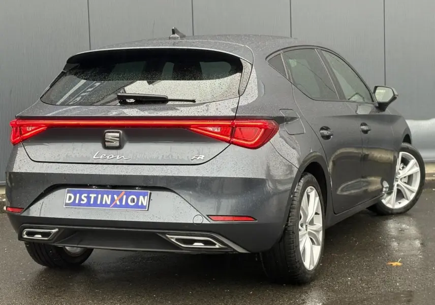 Vue 3/4 arrière droite d'une SEAT Leon 1.5 e-TSI FR gris magnétique avec feux arrière LED et jantes alliage 17 pouces.