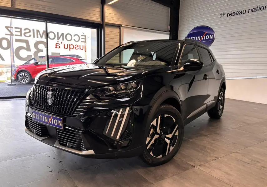 Peugeot 2008 noir en 3/4 avant droit, avec calandre noire et jantes alliage bi-ton dans un showroom.