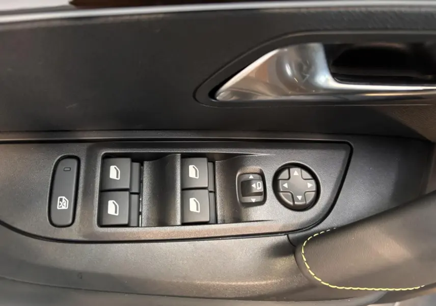 Détail des commandes de lève-vitres et réglage des rétroviseurs côté gauche dans l'habitacle noir du Peugeot 2008 GT 2025.