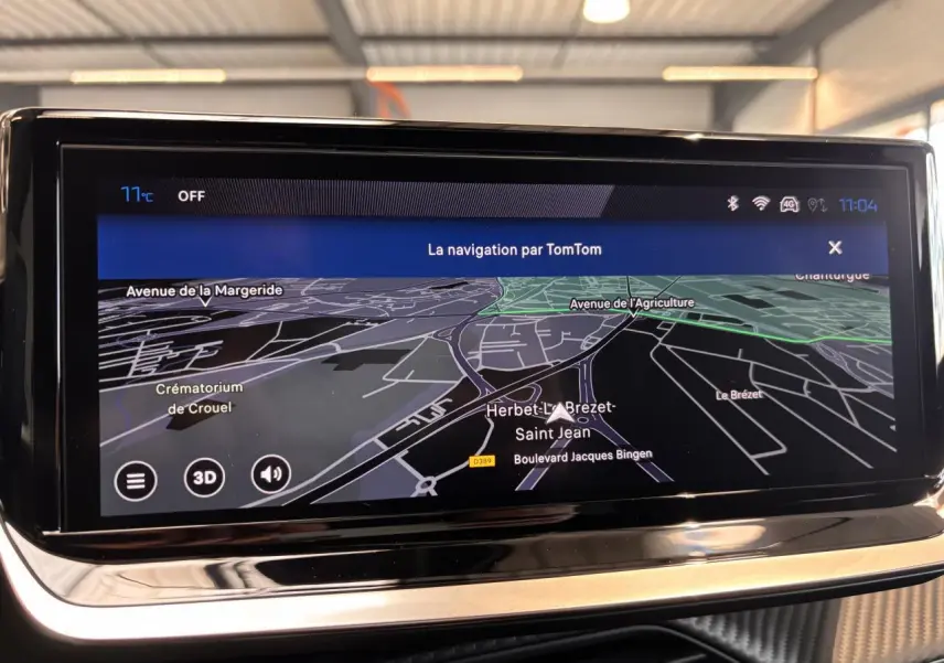 Écran tactile de navigation TomTom affichant une carte en mode 3D dans l'habitacle du Peugeot 2008 noir.