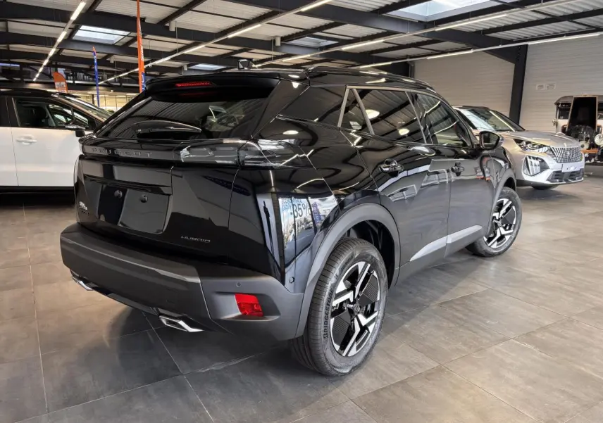 Peugeot 2008 hybride noire vue 3/4 arrière droit en showroom avec jantes bi-ton et feux LED griffés.