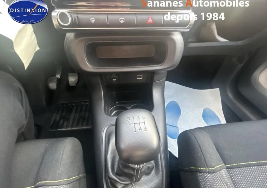 Vue intérieure centrée sur le levier de vitesses manuel de la Citroën C3 gris foncé, avec sièges tissu Mica Grey.