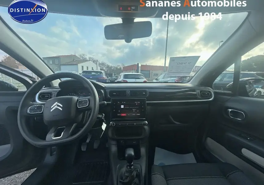 Vue intérieure avant de la Citroën C3 gris foncé 2023, tableau de bord avec écran tactile et volant multifonction.