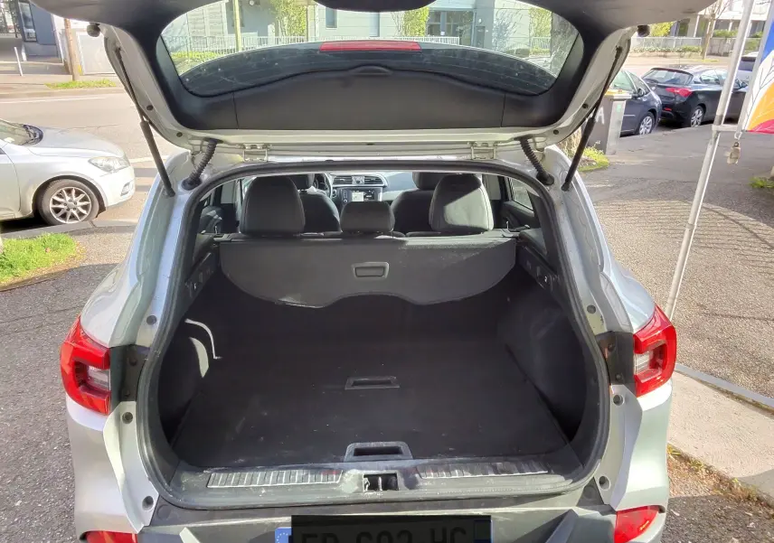 Vue arrière ouverte du Renault Kadjar gris platine métal de 2016, mettant en valeur le coffre spacieux et la lunette arrière.
