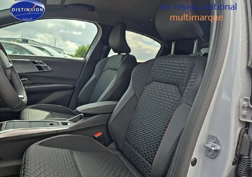 Vue intérieure côté droit de la Renault Clio VI 1.2 TCe 115 Techno EDC, sièges noirs avec surpiqûres et accoudoir central.