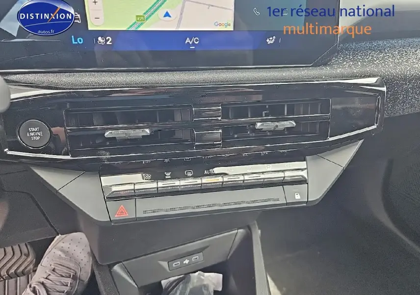 Vue rapprochée du tableau de bord de la Renault Clio VI gris rafale, avec écran tactile et commandes de climatisation.