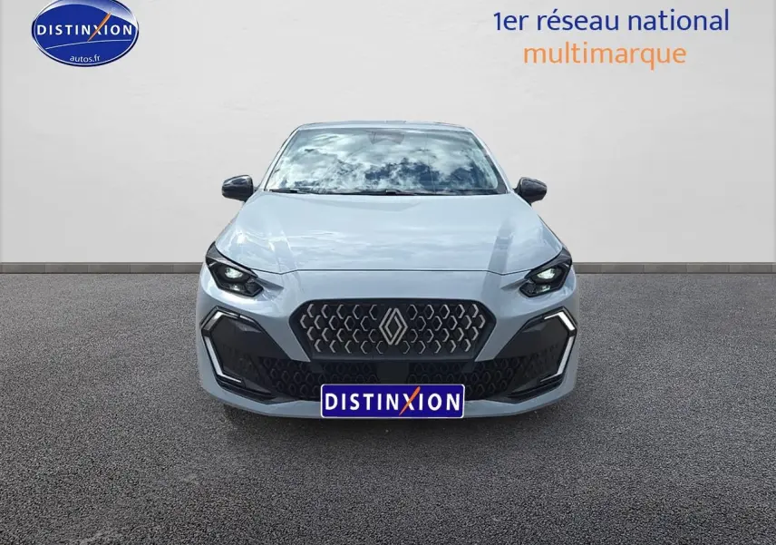 Vue frontale d'une Renault Clio VI gris rafale avec calandre noire et phares LED allumés sur fond neutre.