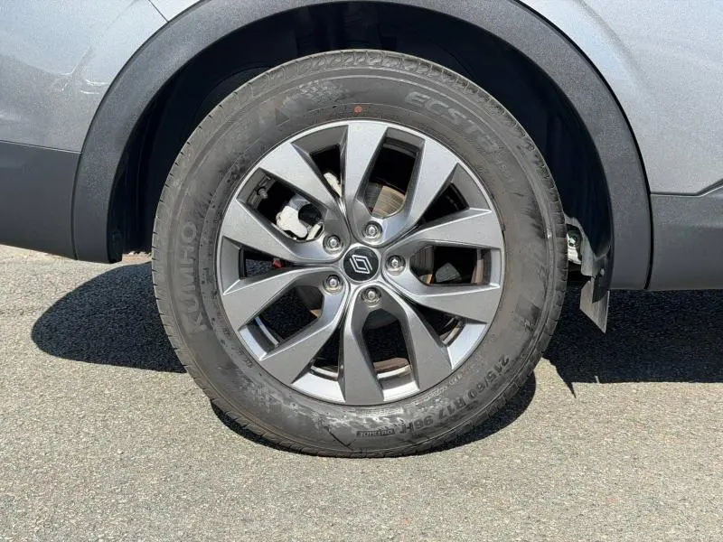 Gros plan sur la roue arrière droite du Renault Arkana gris métallisé 2025 avec jante alliage à cinq doubles branches.