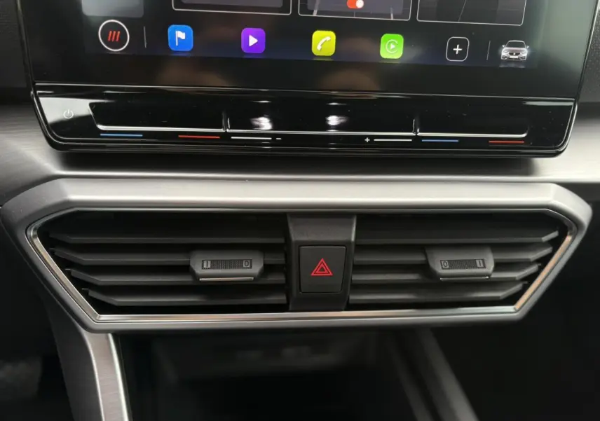 Détail de la console centrale du SEAT LEON 1.5 e-TSI 150 DSG7 FR 2024, montrant les aérateurs et commandes de climatisation.