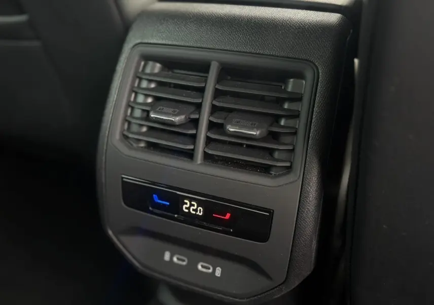 Gros plan sur la commande de climatisation arrière digitale et les prises USB-C du SEAT Leon blanc 2024.