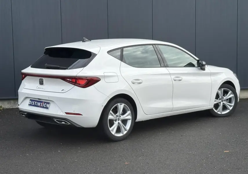 SEAT Leon 1.5 e-TSI 150 DSG7 FR blanc vue 3/4 arrière droit avec jantes alliage 17 pouces et feux LED arrière.