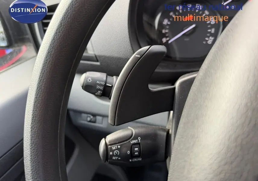 Gros plan sur le volant noir d’un Opel Vivaro 2020, mettant en valeur les commandes de régulateur de vitesse et la palette de changement.