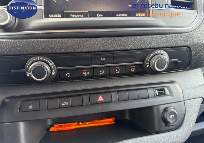 Vue rapprochée du tableau de bord de l'Opel Vivaro 2.0 180CH gris titane, montrant les commandes de climatisation et les boutons centraux.