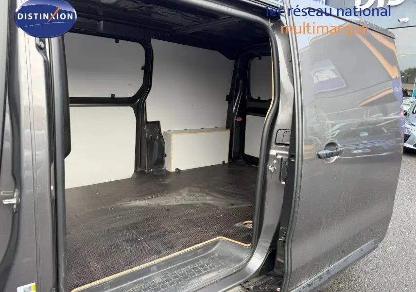 Vue latérale droite d'un Opel Vivaro gris titane métal 2020 avec porte coulissante ouverte montrant l'espace de chargement vide.