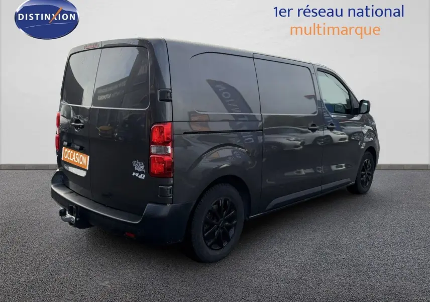 Vue 3/4 arrière droite d’un Opel Vivaro gris titane métallisé avec jantes noires et attelage visible.