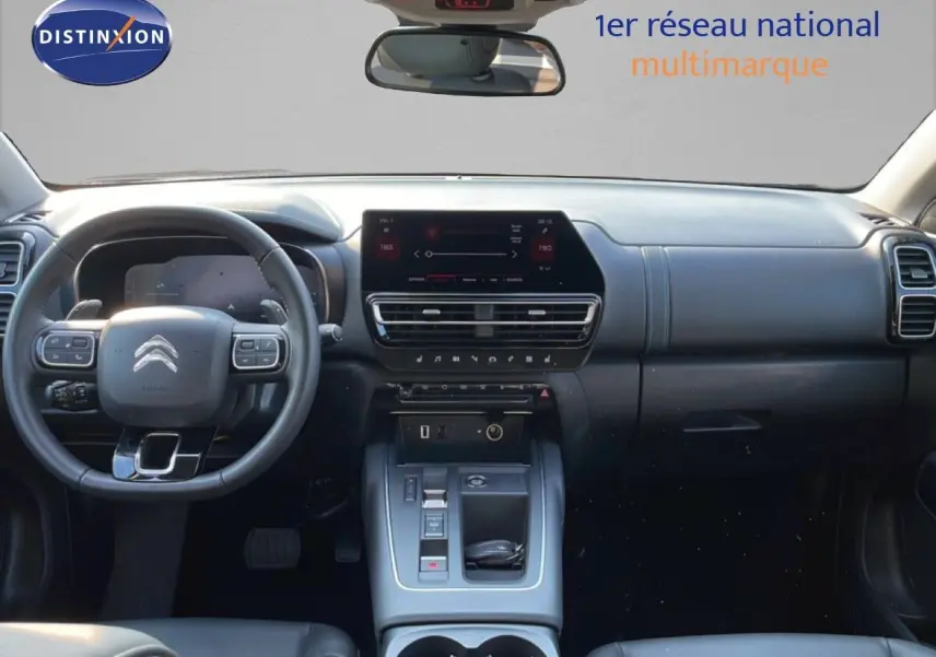 Vue intérieure avant du Citroën C5 Aircross bleu Eclipse Metal, tableau de bord moderne avec écran tactile central et volant multifonction.