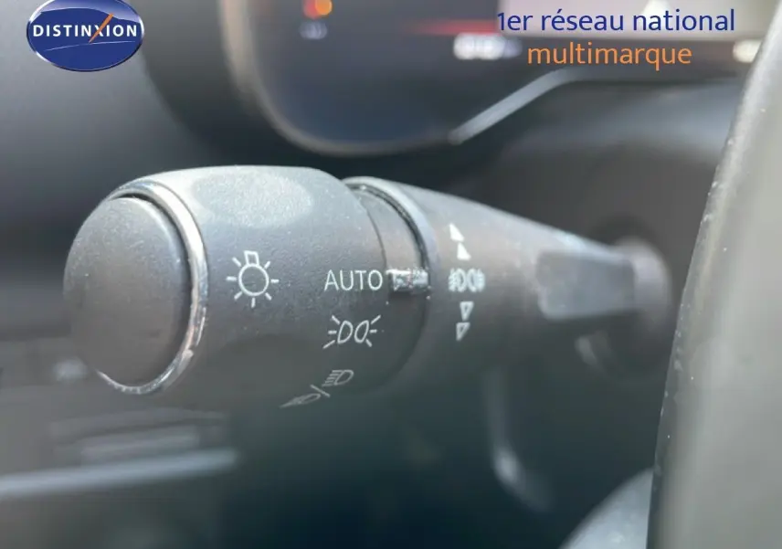 Gros plan sur la commande des phares à gauche du volant dans l'habitacle d'un Citroën C5 Aircross 2025.