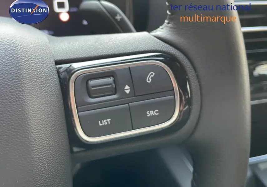 Gros plan sur les commandes gauche du volant du Citroën C5 Aircross 2025 en bleu Eclipse Metal, avec boutons de gestion audio et appel.