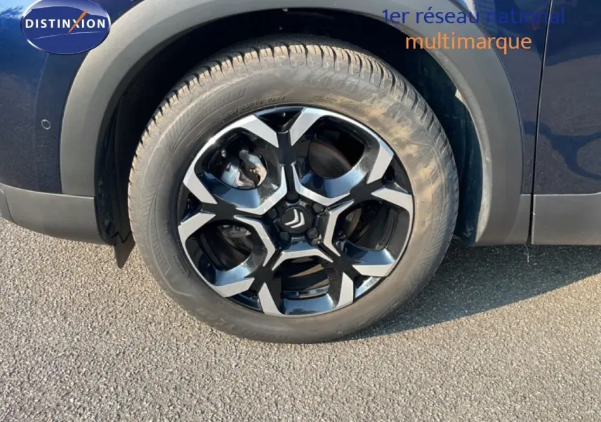 Gros plan sur la roue avant droite du Citroën C5 Aircross bleu Eclipse Métal avec jante alliage bicolore.